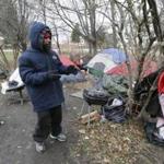 Charles Floyd Jones picked up trash at a tent community on the eastern edge of downtown Detroit on Wednesday.