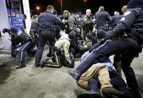 Police try to control a crowd on the lot of a gas station following a shooting Tuesday in the St. Louis suburb of Berkeley. St. Louis County police say a man who pulled a gun and pointed it at an officer has been killed.  (AP Photo/St. Louis Post-Dispatch, David Carson) 
