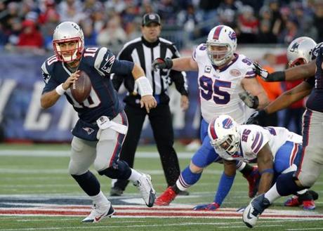 New England Patriots quarterback Jimmy Garoppolo (10) scrambles away from Buffalo Bills defensive tackle Kyle Williams (95) and strong safety Da'Norris Searcy (25) in the second half of an NFL football game Sunday, Dec. 28, 2014, in Foxborough, Mass. (AP Photo/Elise Amendola)
