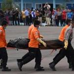 Indonesian officers carry the dead body of a passenger of the crashed AirAsia flight QZ8501 before it is sent to Surabaya, at the base in Pangkalan Bun, the town with the nearest airstrip to the crash site, in Central Kalimantan on January 3, 2015. Search teams have found two big parts of AirAsia Flight 8501, which crashed into the sea last weekend with 162 people on board, the Indonesian chief of the operation said on January 3. AFP PHOTO / ADEK BERRYADEK BERRY/AFP/Getty Images