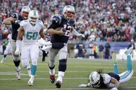 New England Patriots quarterback Tom Brady (12) runs with the ball as Miami Dolphins defensive end Olivier Vernon (50) gives chase in the second half of an NFL football game Sunday, Dec. 14, 2014, in Foxborough, Mass. (AP Photo/Steven Senne)
