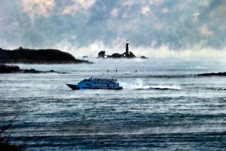 A ferry maneuvered through sea smoke and zero degree temperatures past Boston Light on an early morning trip.
