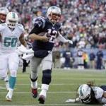 New England Patriots quarterback Tom Brady (12) runs with the ball as Miami Dolphins defensive end Olivier Vernon (50) gives chase in the second half of an NFL football game Sunday, Dec. 14, 2014, in Foxborough, Mass. (AP Photo/Steven Senne)
