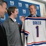 Governor Charlie Baker showed off his University of Massachusetts Lowell hockey jersey from coach Norm Bazin (left) and player A.J. White. The school also revealed a $4 million donation from Robert Manning, and his wife, Donna.