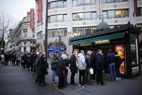 People waited in line to get a copy of satirical French magazine Charlie Hebdo in front of a kiosk in Paris.
