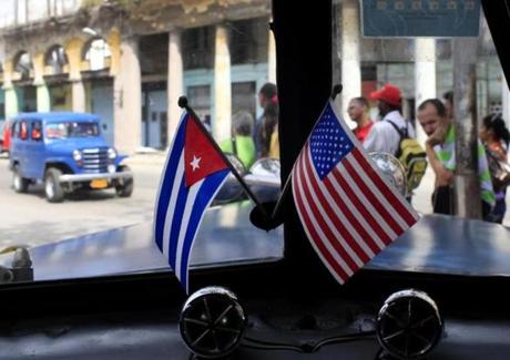 Miniature flags representing Cuba and the US were displayed on the dash of a classic American  car in Havana.
