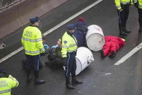 A medic attended to a protester who attached himself to a concrete-filled barrel during Thursday?s morning rush hour. 
