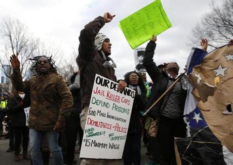 Participants in a rally in Boston on Martin Luther King Day held signs and chanted. 
