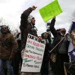 Participants in a rally in Boston on Martin Luther King Day held signs and chanted. 