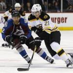 Boston Bruins right wing Loui Eriksson, front, of Sweden, drives down the ice with the puck as Colorado Avalanche right wing Jarome Iginla defends in the second period of an NHL hockey game Wednesday, Jan. 21, 2015, in Denver. (AP Photo/David Zalubowski)