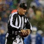 Umpire Carl Paganelli holds a football on the field after a play during the AFC Championship game.