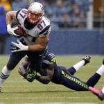 Safety Kam Chancellor tries to drag down the Patriots? Rob Gronskowski during a 2012 game. (AP Photo/Elaine Thompson, File)