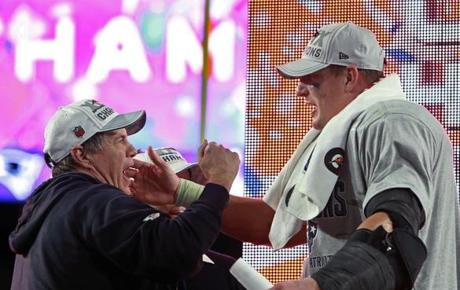 Coach Bill Belichick and tight end Rob Gronkowski move to congratulate each other after Super Bowl XLIX.
