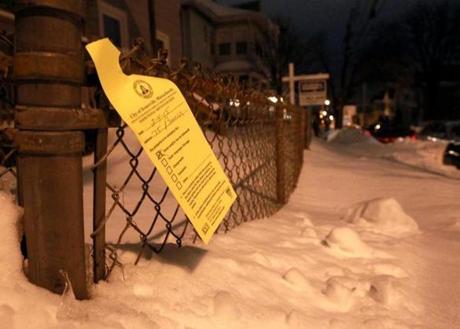 A notice that hangs from fence outside a home on in Somerville.
