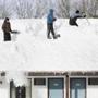 Workers removed snow from the roof of the Seabrook Inn in Seabrook, N.H., on Friday.
