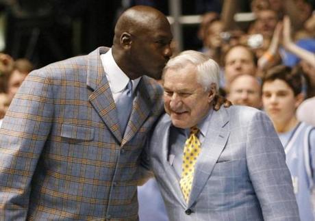 Former University of North Carolina player and NBA standout Michael Jordan (L) kisses former University of North Carolina head coach Dean Smith during a ceremony honoring the 1957 and 1982 national championship teams at halftime of the NCAA basketball game between North Carolina and Wake Forest University in Chapel Hill, North Carolina, in this file photo taken February 10, 2007. Smith, a legendary head basketball coach at the University of North Carolina whose proteges include NBA great Michael Jordan, has died at age 83, the university reported on its website on Sunday. REUTERS/Ellen Ozier/Files (UNITED STATES - Tags: SPORT BASKETBALL OBITUARY)
