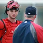 02/25/14: Ft. Myers, FL: FOR POSSIBLE USE WITH BASEBALL PREVIEW SECTION.........Red Sox catching prospects Blake Swihart (left), and Christian Vazquez (right) are pictured talking to bullpen coach Dana LeVangie (center). (Jim Davis/Globe Staff) section:sports topic:Red Sox Spring Training