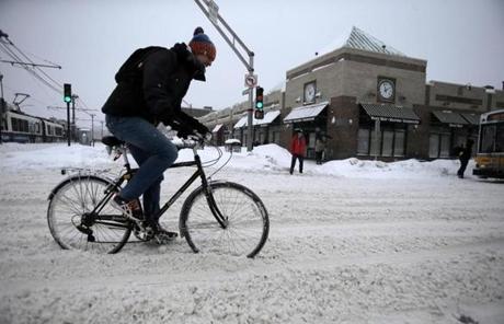 Allston, MA - 02/9/15 - A cyclist crosses Commonwealth Avenue on Harvard Avenue in Allston as another storm dropped still more snow on the city. Lane Turner/Globe Staff Section: METRO Reporter: various Slug:

