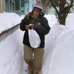 Pierre Simon walked through the snowbanks Thursday in Jamaica Plain to deliver a meal to a couple.