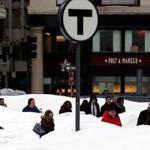 Mounds of snow surrounded commuters at an MBTA stop in downtown Boston on Thursday. Snow and rain are forecast over the weekend.