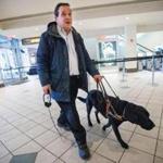 Carl Richardson and his service dog enter AMC Loews Boston Common Theater to take in ?American Sniper.? Richardson received a special hearing device to enjoy the film.