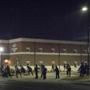 Police stood guard outside the Ferguson, Mo., police headquarters Thursday, moments after gun shots were fired.