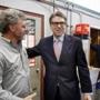 Former Republican Texas Governor Rick Perry (right) spoke with Weed Automotive owner Dan Weed on Thursday in Concord, N.H. 