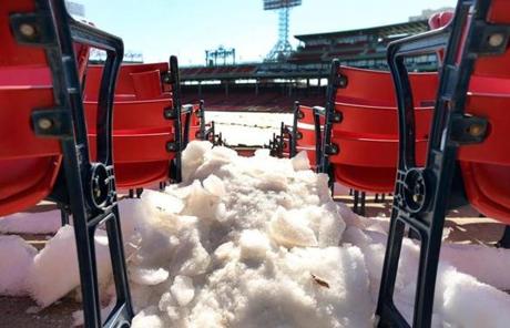 Snow was spotted between the rows of seats behind home plate at Fenway Park. 
