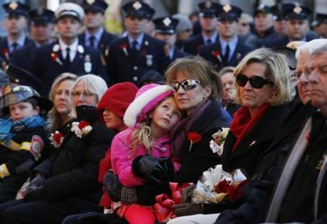 Kristen Walsh, widow of Boston Fire Lieutenant Edward Walsh, held her daughter Morgan, 6. They sat beside Kathy Crosby-Bell, mother of Firefighter Michael Kennedy. 

