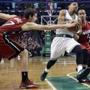Boston Celtics guard Phil Pressey splits the defense of Miami Heat guards Goran Dragic (7) and Shabazz Napier (13) as he drives to the hoop in the second half of an NBA basketball game in Boston, Wednesday, March 25, 2015. The Heat won 93-86. (AP Photo/Elise Amendola)