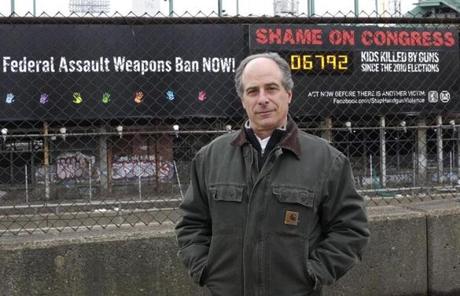 John Rosenthal, founder and president of Stop Handgun Violence, in front of the landmark billboard along the Massachusetts Turnpike.
