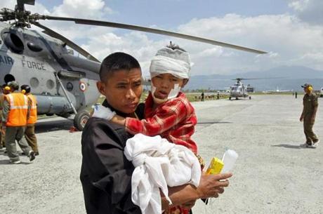 A man carried an injured child, who was wounded in Saturday's earthquake, after Indian Army soldiers evacuated them from Trishuli Bazar to the airport in Kathmandu.
