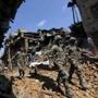 Nepal soldiers carried a body recovered Monday from the rubble of a house in Bhaktapur