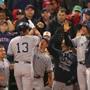 Teammates greet Alex Rodriguez in the dugout after his home run.