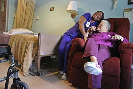 Nursing assistant Felicia Togba (left) with Maria Alvarez, a resident at Steere House, a nursing and rehab facility in Providence. 

