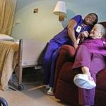 Nursing assistant Felicia Togba (left) with Maria Alvarez, a resident at Steere House, a nursing and rehab facility in Providence. 