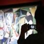 epaselect epa04743983 A person takes a cellphone photo of the Pablo Picasso painting 'Les femmes d'Alger (Version 'O'), oil on canvas on display prior an auction at Christie's in New York, NY, USA, 11 May 2015. The painting set a new record world auction record for any work of art selling for 160 million US dollar (142.9 million euro) plus auction fees of 12 percent, costing a total of 179.3 million US dollar. EPA/JASON SZENES