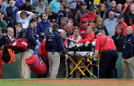 Boston, MA - 06/05/15 - (2nd inning) Medical personnel remove a fan injured by a broken bat in the second inning. The Boston Red Sox take on the Oakland Athletics in Game 1 of a three game series at Fenway Park. - (Barry Chin/Globe Staff), Section: Sports, Reporter: Julian Benbow, Topic: 06Red Sox-A's, LOID: 8.1.1046911126. 
