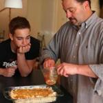 In his Newton kitchen, Ted Gilman and his son Noah make mac and cheese from Gilman?s grandmother?s recipe, sprinkling the top with buttered breadcrumbs before it goes in the oven.