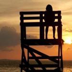 With the sun nearing the horizon across Ipswich Bay, Mae Hebert, 7, watched from the lifeguard chair at Plum Cove Beach in Gloucester on Tuesday.