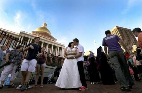 Liz Nania (left) and Sandy Bailey, married for one year, celebrated the Supreme Court?s ruling Thursday with a kiss and a dance on the State House steps in Boston. 
