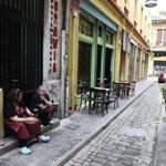 Employees of a restaurant talk on an empty street in the northern Greek port city of Thessaloniki, Tuesday, June 30, 2015. Greek Finance Minister Yanis Varoufakis confirmed that the country will not make its payment due later to the International Monetary Fund. Capital controls began Monday and will last at least a week, an attempt to keep the banks from collapsing in the face of a nationwide bank run. (AP Photo/Giannis Papanikos) 