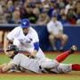 Boston Red Sox Mike Napoli steals third base as Danny Valencia attempts to tag him during third inning American League baseball action in Toronto on Tuesday, June 30, 2015. (Frank Gunn/The Canadian Press via AP) MANDATORY CREDIT