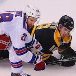 Boston-01/15/15- The Boston Bruins vs New York Rangers- Bruins Reilly Smith falls to the ice in pursuit of the puck in the 2nd period with Rangers Domenic Moore. Boston Globe staff photo by John Tlumacki(sports)