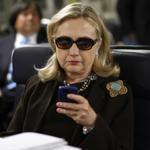 Then-secretary of state Hillary Clinton checks her Blackberry from a desk inside a military plane in 2011.
