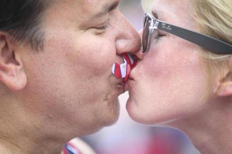 John and Erin Pennington kissed while wearing American flag themed mustaches.
