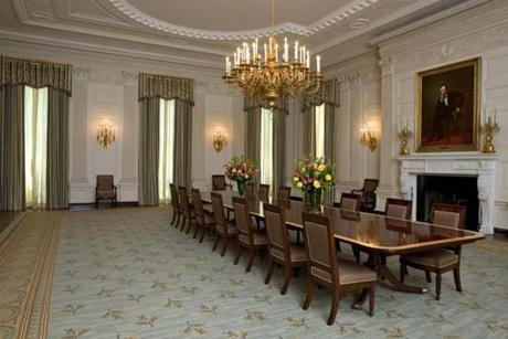 The State Dining room of the White House has been refurbished with new arm chairs, side chairs, and draperies suspended from carved and gilded poles.
