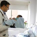 Dr. Dan Hale (above) checks in on newborn Nazierre Sanchez as he makes patient rounds at Lawrence General Hospital.  