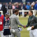 Dustin Johnson (center) shakes hands with Jordan Spieth after they completed the first round of the British Open.