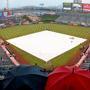 A lone fan sits in the rain during a rain delay prior to a baseball game between the Los Angeles Angels and the Boston Red Sox, Sunday, July 19, 2015, in Anaheim, Calif. (AP Photo/Mark J. Terrill) 